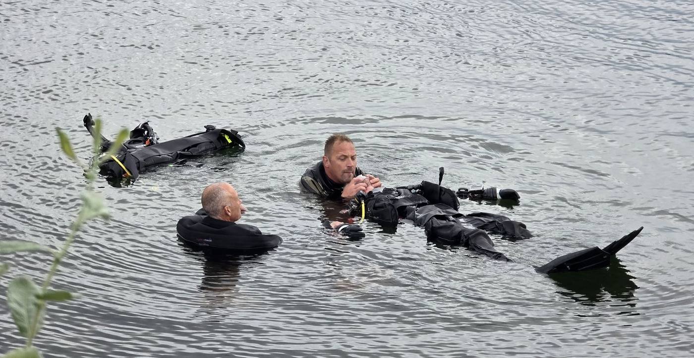 Drysuit divers practising skills at the surface of a UK lake