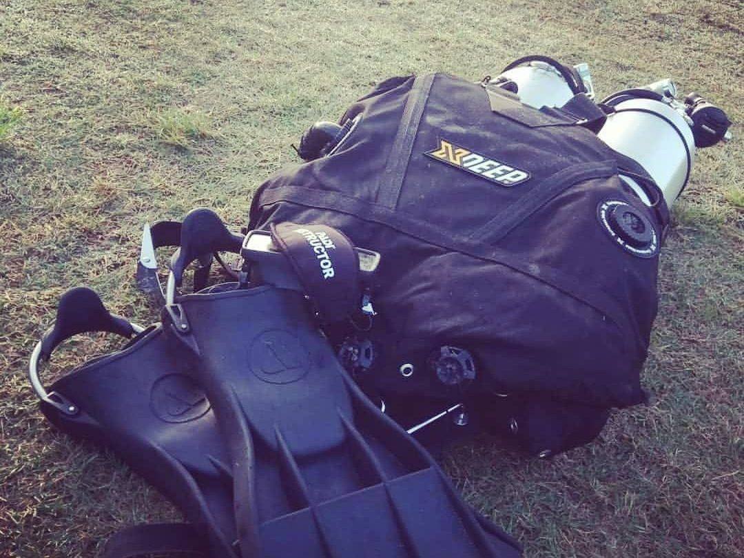 Twin cylinders on an XDeep harness with fins, laid out on the grass ready to dive